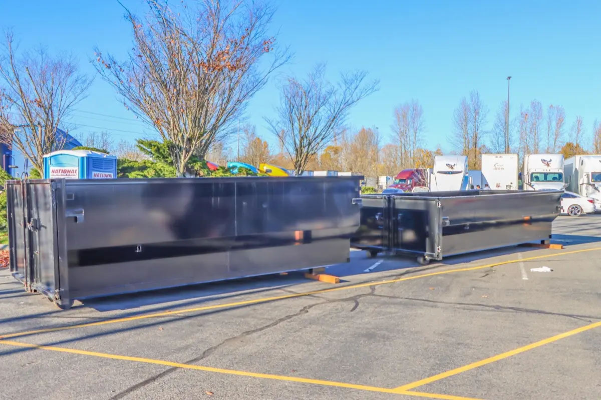 Professional dumpster rental service with roll-off container on residential driveway in West Springfield Town